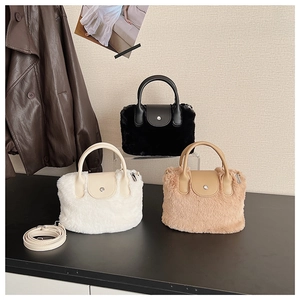 Three plush faux fur bucket bags in white, black and brown with leather handles and straps