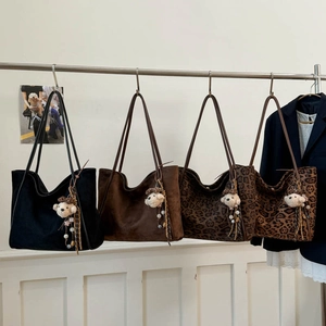 Detailed view of large tote bags in leopard print and suede with plush bear charms