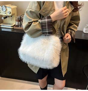 Detailed close-up of fluffy white faux fur tote bag with golden metal chain strap