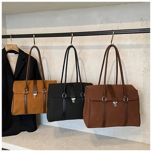 Tre borse tote minimaliste in pelle scamosciata gialla, nera e marrone su ganci
