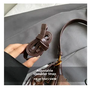 Detail showing the adjustable dark brown leather strap with a gold-tone buckle