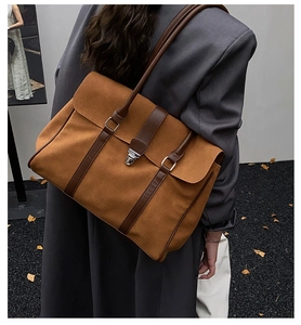 Vista laterale dettagliata di una grande borsa tote color caramello indossata da un modello
