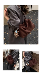 Detailed close-up of dark brown suede tote bag with cute teddy bear charm pendant