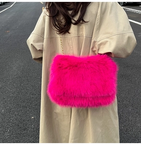Detail showing plush texture and gold chain on rose red faux fur crossbody tote bag
