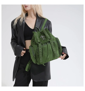 Close-up of green vintage suede backpack with silver studs and metal cross detail