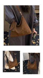 Detail of a large brown suede hobo bag with gold hardware and a matching small pouch