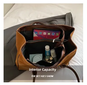 Vista dall'alto dell'interno della grande borsa tote marrone con scomparti e oggetti quotidiani