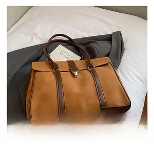 Dettaglio della borsa tote in pelle scamosciata con spalline in cuoio e fibbia in metallo