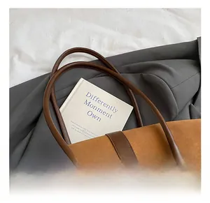 Dettaglio della borsa tote in pelle scamosciata marrone con manici in pelle e fibbie argento