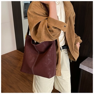 Detail of burgundy matte tote bag featuring high-contrast white stitching and large capacity