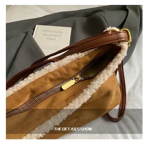 Detail of golden zipper and white faux shearling trim on a brown suede tote bag
