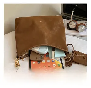 Brown matte hobo bag interior capacity showing tablet, phone, and matching mini pouch