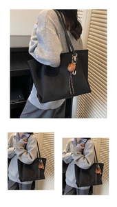 Detailansicht der schwarzen minimalistischen Tragetasche mit braunem Bärenanhänger