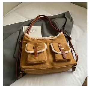 Detail showing vintage brown suede bag with faux shearling trim and front pockets