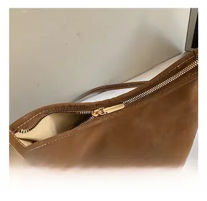 Detail of premium golden zipper and brown suede texture on vintage tote bag