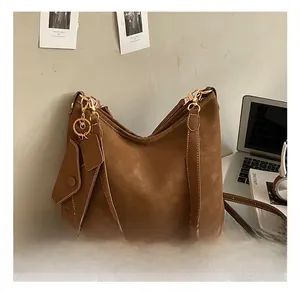 Detail of brown matte leather hobo bag with gold hardware and mini envelope charm