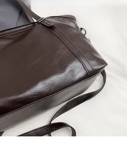 Detail of soft dark brown leather tote bag showing glossy texture and fine stitching