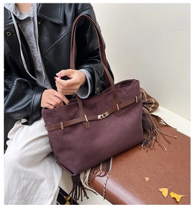 Détail du sac cabas en daim bordeaux avec lanières en cuir marron et boucle métallique