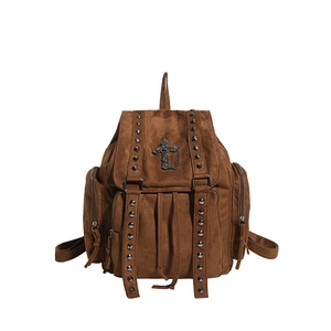 Nahaufnahme des braunen Wildlederrucksacks mit Nieten und Metallkreuzanhänger