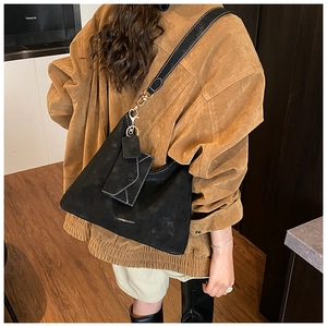 Detail of black suede tote bag with white contrast stitching and matching small pouch
