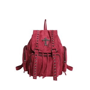 Detail eines gotischen weinroten Nietrucksacks mit Metallkreuz und Kettenverzierung