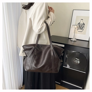Detail of dark brown faux leather tote bag with silver star rivet on the shoulder strap