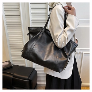 Detail of black faux leather tote bag with metal star studs and soft texture