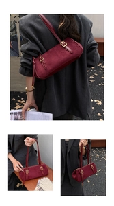 Detail view of burgundy faux suede baguette bag with vintage texture and gold buckle