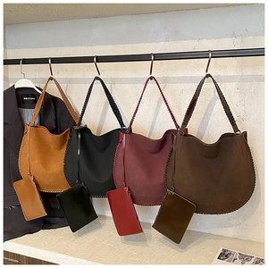 Detailed view of large faux suede tote bag set with decorative braided stitching details