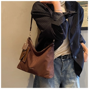Detail of soft brown suede tote bag featuring a mini matching coin purse and gold logo
