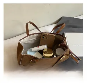 Internal capacity of brown suede underarm bag showing space for phone and cosmetics