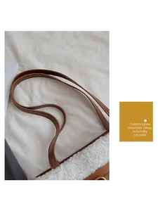 Detail showing the brown leather strap and white fuzzy sherpa texture on a bucket bag