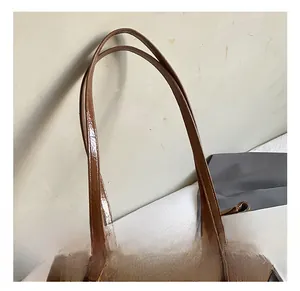 Detail showing the retro brown leather handle and gold buckle of this minimalist bag