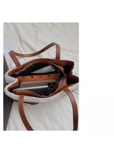 Close-up of spacious interior of brown leather and white plush tote bag holding essentials