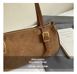 Detail of adjustable shoulder strap with gold buckle on brown vintage leather bag