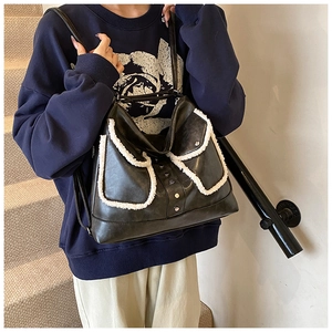 Detail showing plush trim on black PU leather shoulder bag with silver hardware accents