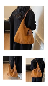 Detail view of a large brown suede tote bag with a matching shoulder strap and small pouch