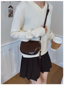 Détail du sac de selle marron foncé en cuir ciré brillant avec pendentif en perles