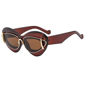 Lunettes de soleil œil-de-chat avec monture ambre et détails dorés sur fond blanc