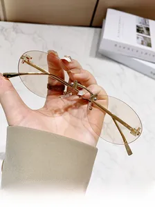 Detail of rimless oval sunglasses with diamond-set T-shaped metal gold temples