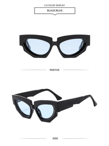 Detail of chunky cat-eye sunglasses with thick black frame and blue tinted lenses