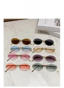 Detail view of eight colorful rimless oval sunglasses with golden metal frames and accents