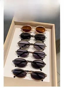 Détail de six lunettes de soleil ovales vintage en métal avec montures texturées sur plateau