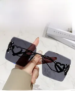 Détail de lunettes de soleil carrées sans monture avec strass en forme de cœur