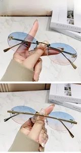 Close-up of rimless oval sunglasses with blue-pink gradient lenses and gold F-logo detail
