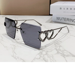 Détail de lunettes de soleil carrées sans monture avec branches à double cœur et rivets