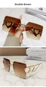 Détail de lunettes de soleil carrées sans monture avec verres dégradés et cœur doré