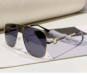Détails de lunettes aviateur dorées avec branches ajourées et verres gris élégants