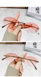 Detail of rimless oval sunglasses with pink gradient lenses and crystal F metal hinges