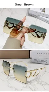 Détail de lunettes de soleil sans monture dégradé marron avec branche en métal à cœur doré